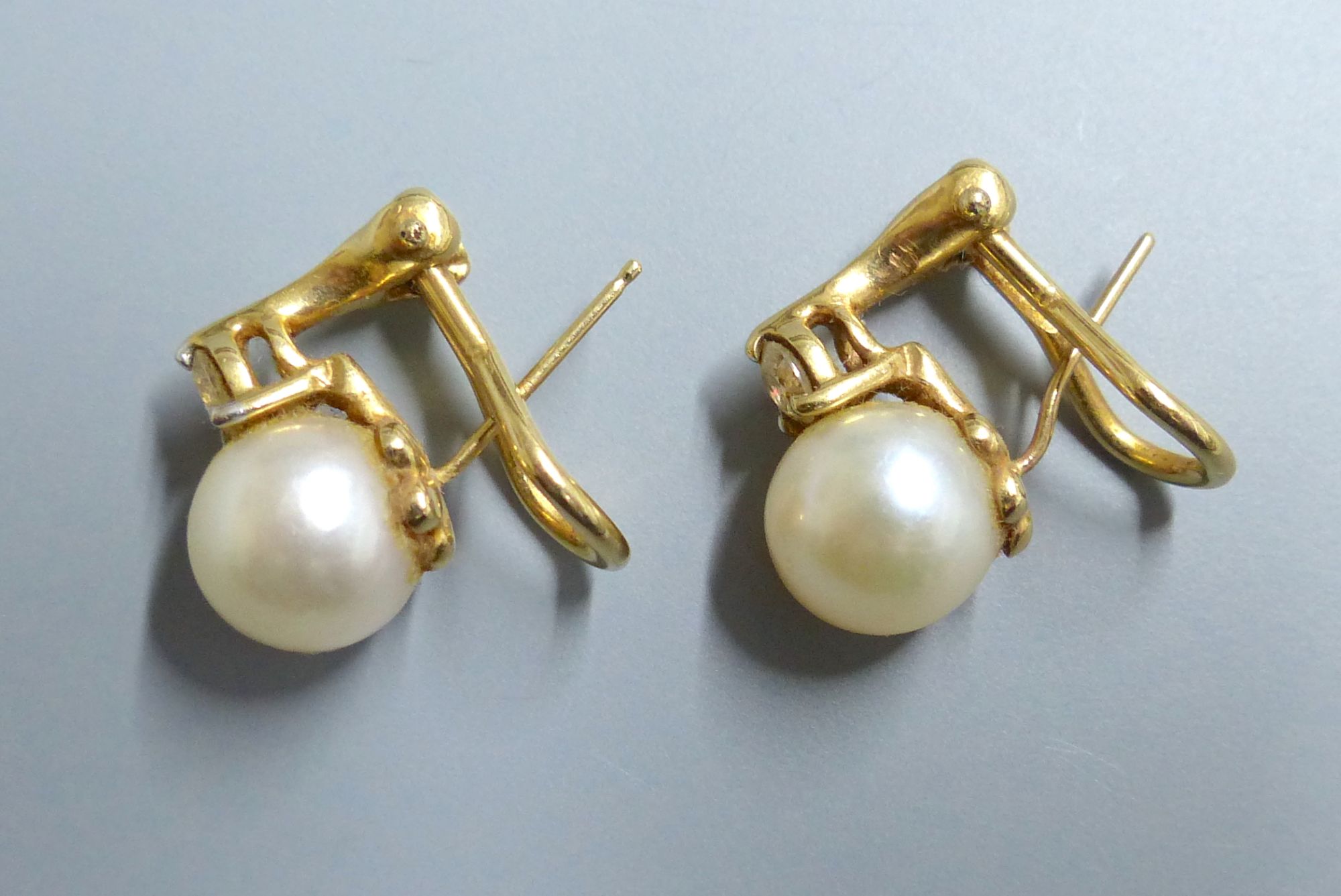 A modern pair of 14k, cultured pearl and diamond set earclips, gross 5.1 grams,